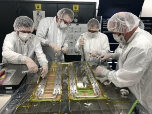 Europa Clipper technicians and engineers at NASA's Jet Propulsion Laboratory in Southern California work together in a cleanroom on Sept. 12, 2019. They bond thermal tubing to the spacecraft's Radio Frequency (RF) panel, which was built by Johns Hopkins University Applied Physics Laboratory (APL) in Laurel, Maryland. The tubing is part of a Heat Redistribution System (HRS) that pumps coolant all around the spacecraft and helps control its temperature as it travels through space. Photo Credit: NASA/JPL-Caltech