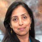 Portrait of Dr. Swara Ravindranath. She has dark hair and wears a dark blazer. 