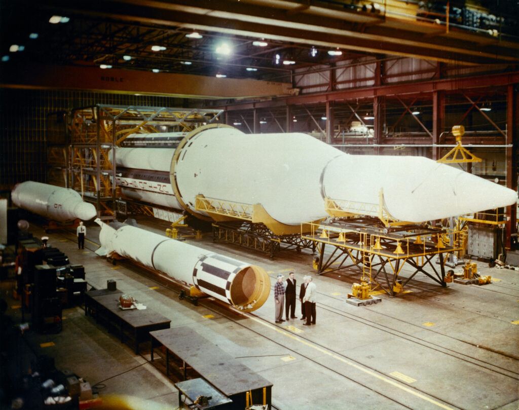 The flight configuration of the giant three-stage Saturn C-1 rocket (later called Saturn I Block I) is seen in the Fabrication and Assembly Engineering Division at MSFC. Dwarfed by the 180-foot C-1 are a Juno II rocket (left rear) and a Mercury-Redstone rocket (front foreground). Credit: NASA