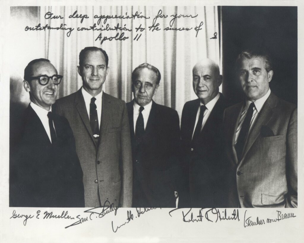 This historical photograph is of the Apollo Space Program Leaders. An inscription appears at the top of the image that states, “Our deep appreciation for your outstanding contribution to the success of Apollo 11”, signed “S”, indicating that it was originally signed by Apollo Program Director General Sam Phillips, pictured second from left. From left to right are; NASA Associate Administrator George Mueller; Phillips; Kurt Debus, Director of the Kennedy Space Center; Robert Gilruth, Director of the Manned Spacecraft Center, later renamed the Johnson Space Center; and Wernher von Braun, Director of the Marshall Space Flight Center. Credit: NASA