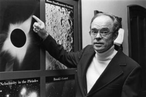 Eugene Parker in 1977 pointing at an image of a total solar eclipse revealing solar wind features. Credit: University of Chicago