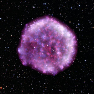 Composite image of IXPE data showing the Tycho supernova remnant, which looks like a purple, fluffy dandelion against a starry field. Dark purple and white have been combined with data from NASA’s Chandra X-ray Observatory (red and blue) and overlaid with the stars in the field of view as captured by the Digitized Sky Survey. Image Credit: X-ray (IXPE: NASA/ASI/MSFC/INAF/R. Ferrazzoli, et al.), (Chandra: NASA/CXC/RIKEN & GSFC/T. Sato et al.) Optical: DSS Image processing: NASA/CXC/SAO/K. Arcand, L.Frattare & N.Wolk
